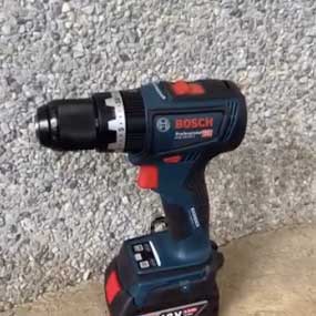 Un taladro inalámbrico azul Bosch Professional está de pie en el suelo.