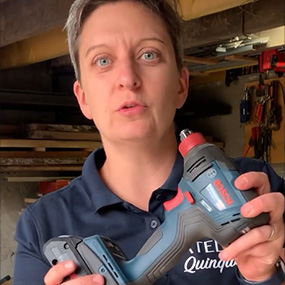 Une femme tient un tournevis sans fil bleu Bosch Professional dans sa main.