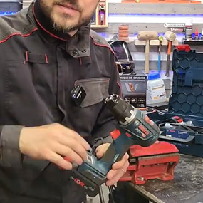 Un homme tient une perceuse sans fil Bosch Professional dans un atelier.