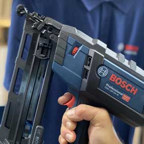 Un chiodatore a batteria Bosch Professional è tenuto in una mano.