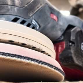 Un dispositivo di levigatura Bosch Professional è posato su un banco da lavoro, nero e rosso.