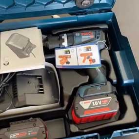 Um conjunto de ferramentas sem fio Bosch Professional em uma caixa azul, acessórios visíveis.