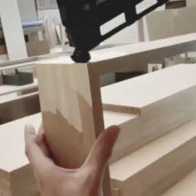 Uma mão segura madeira enquanto uma ferramenta está posicionada acima dela.