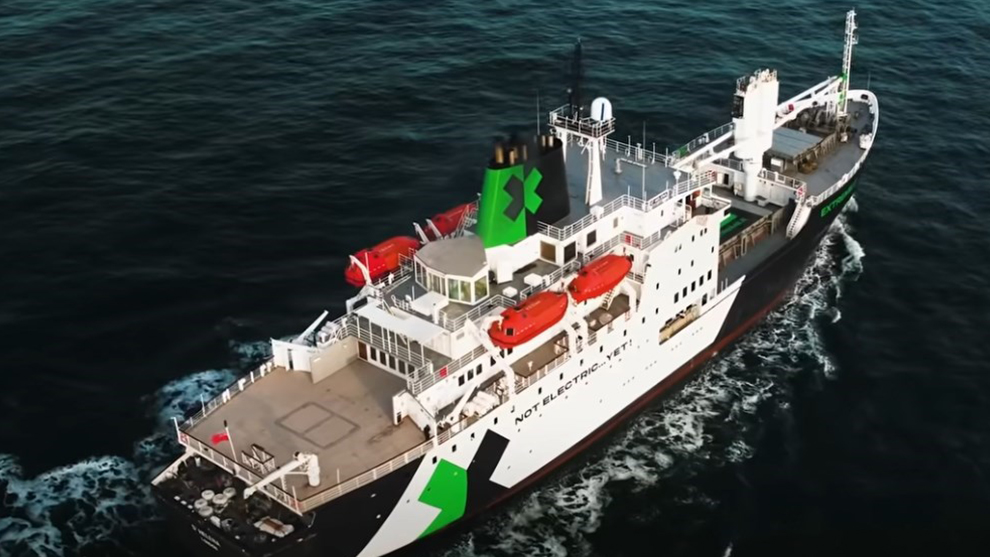 Ein Schiff mit grüner und schwarzer Farbe fährt durch das Wasser.