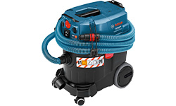 Un aspirapolvere blu Bosch Professional è posizionato su un pavimento, pronto per l'uso.