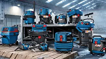 Vários aspiradores azuis Bosch Professional estão em uma prateleira de madeira.