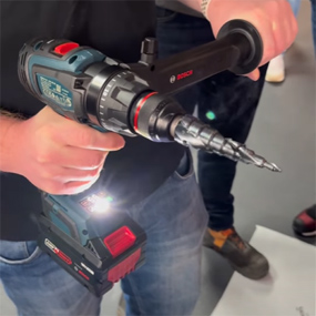 Ein Bosch Professional Akku-Schrauber wird von einer Person gehalten, mit einem Metallbohrer und LED-Licht.
