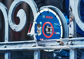 Синій професійний різак Bosch ріже металеву сітку.