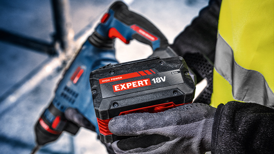 Акумулятор Bosch Professional з червоним написом, утримується в робочих рукавицях.