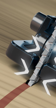 Muž s ochrannými brýlemi a chrániči sluchu drží elektrickou pilu nad dřevěnou deskou.