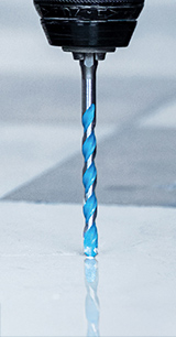 Sinine spiraalpuur hõljub peegeldaval pinnal, valmis puuri tegema.