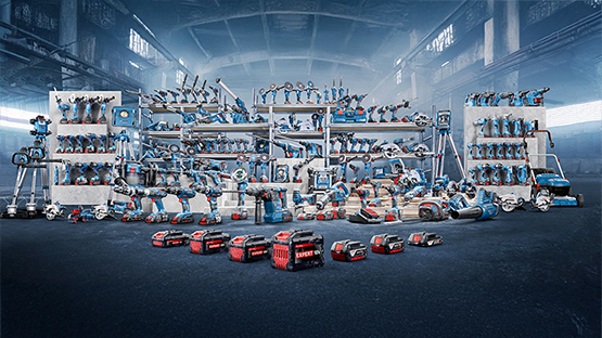 A variety of blue Bosch Professional tools are on shelves in an industrial environment.