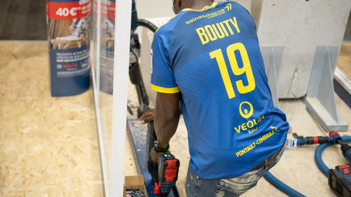 Un homme en maillot bleu utilise un outil Bosch Professional.