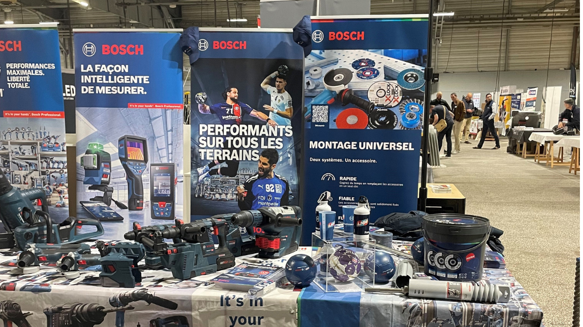 Outils professionnels Bosch sur une table d'exposition avec des affiches.