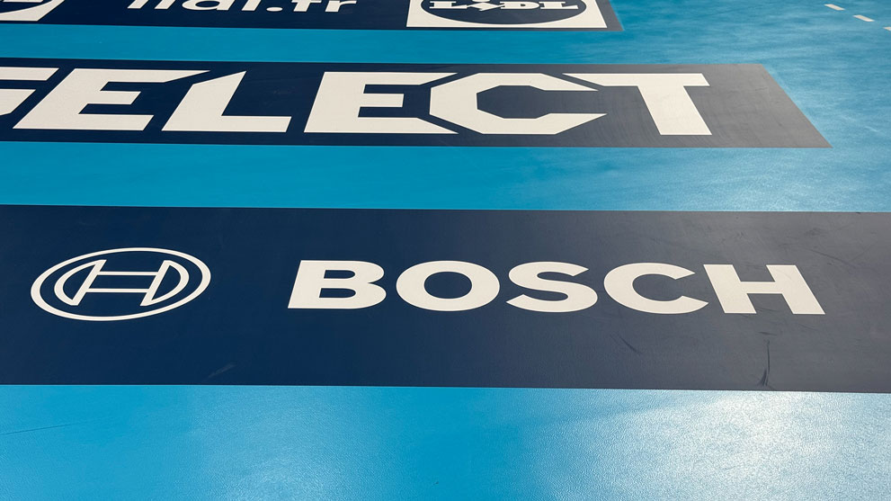 Sol avec des zones bleues et noires, logos de marques Bosch et Select.