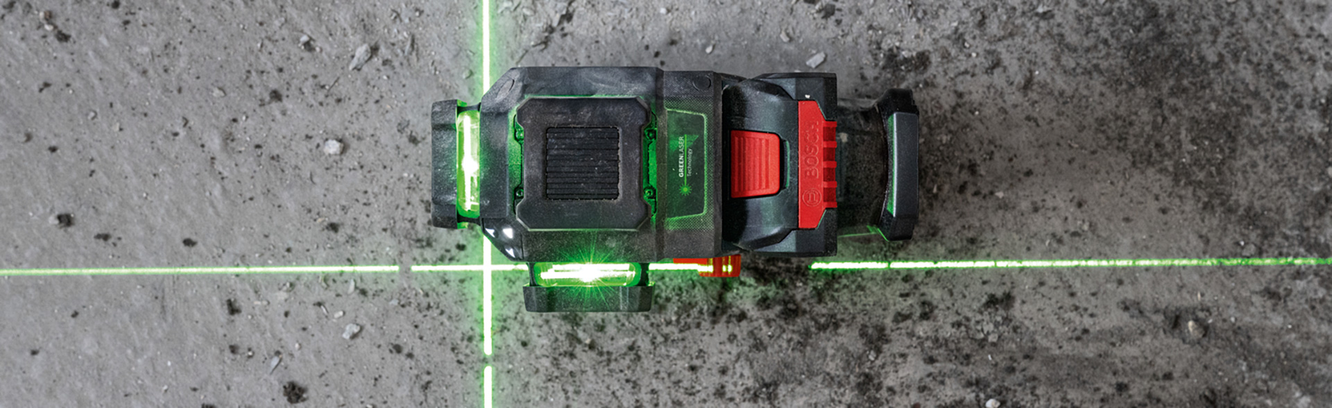 En Bosch Professional laser-nivå på ett grått golv.