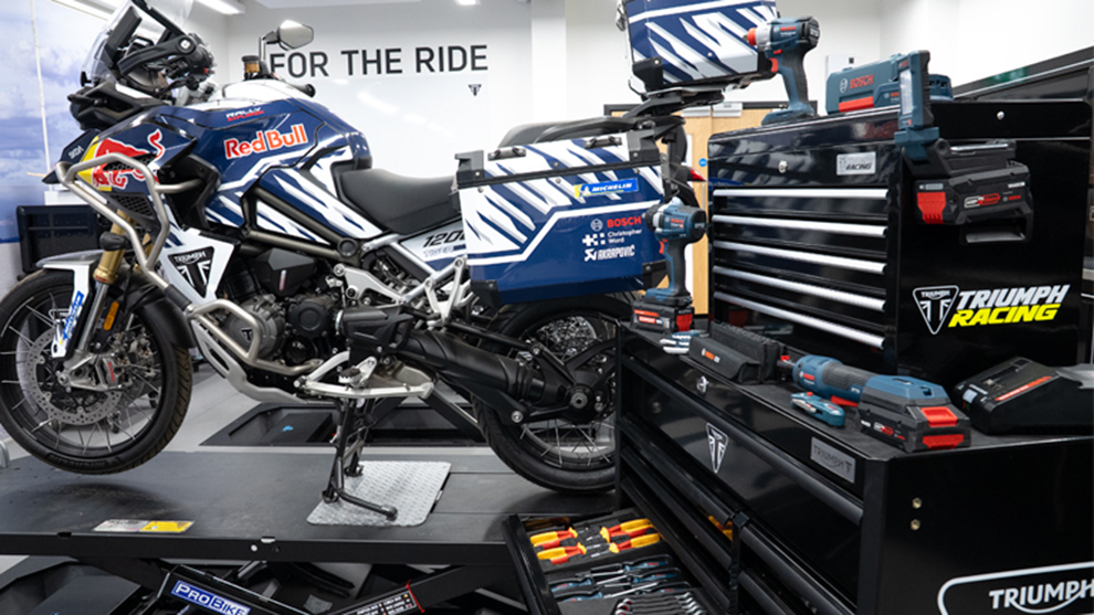 A motorcycle with Red Bull livery stands on a workbench, surrounded by Bosch Professional tools.