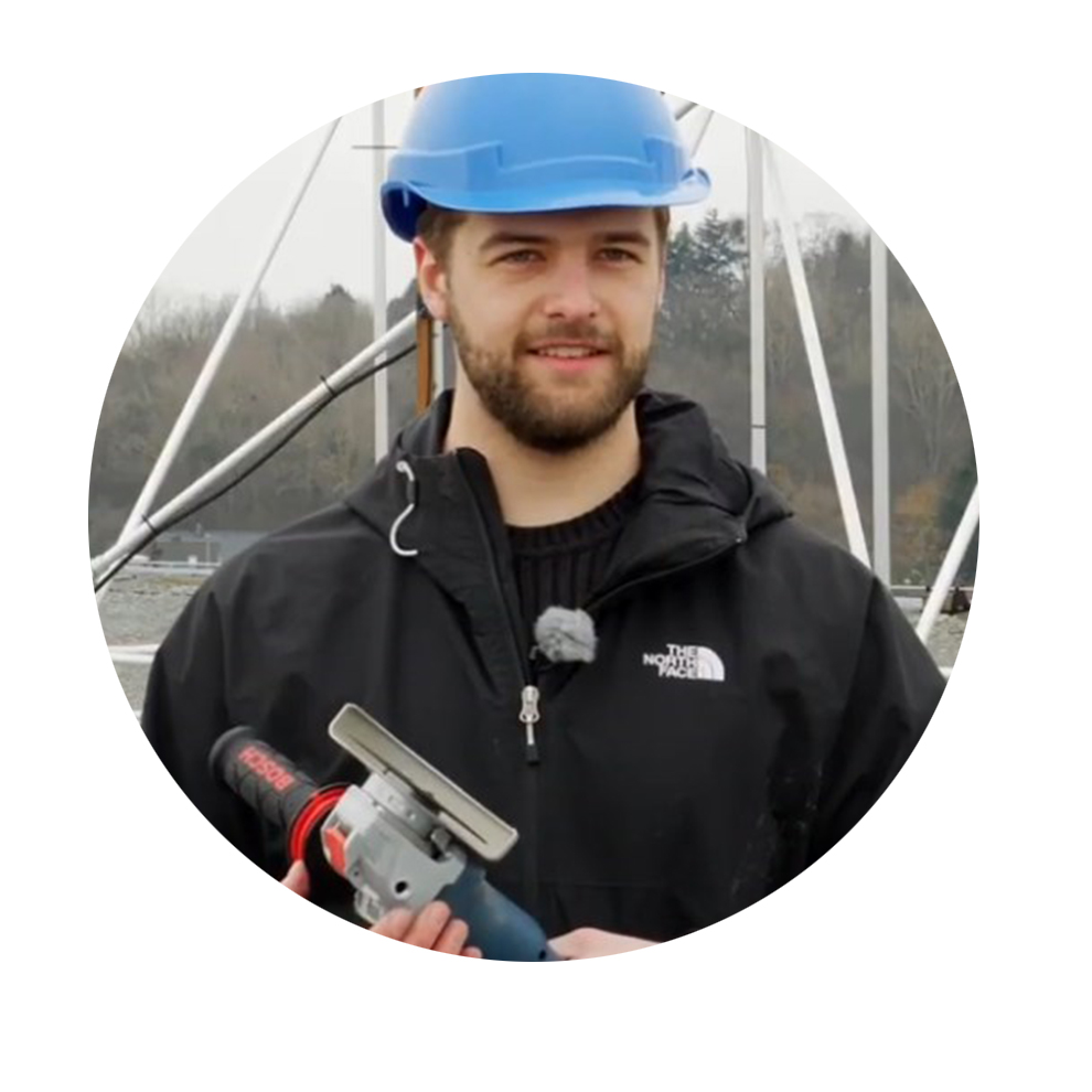 En man med blå byggmössa håller ett Bosch-verktyg i handen.