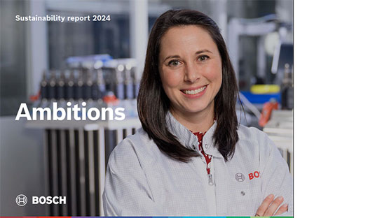 En leende kvinna i en vit Bosch-kittel står framför maskiner.