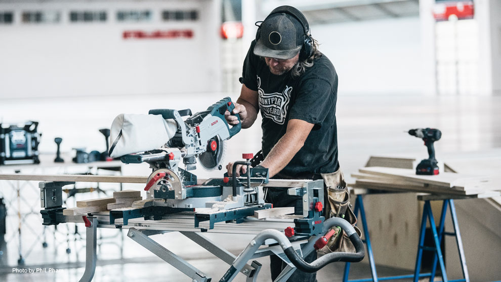 Ένας τεχνίτης χρησιμοποιεί μια πριόνι Bosch σε ένα τραπέζι εργασίας.