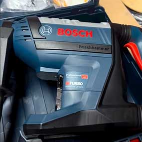 A blue Bosch Professional hammer drill is lying in a toolbox.
