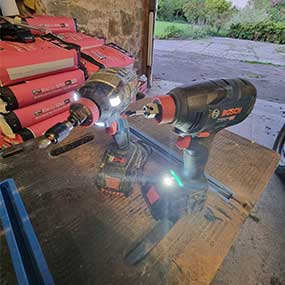 Two Bosch Professional cordless screwdrivers are on a table in the workshop light.