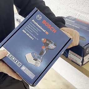 A person is holding a Bosch Professional tool box in their hand.