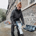 Eine Frau in schwarzer Arbeitskleidung bedient einen Bosch Abbruchhammer.
