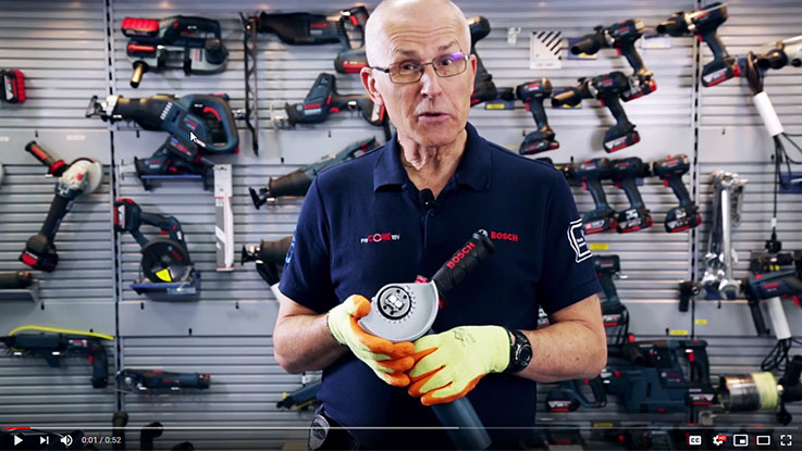 A man holds a Bosch Professional tool in his hand, surrounded by other tools.