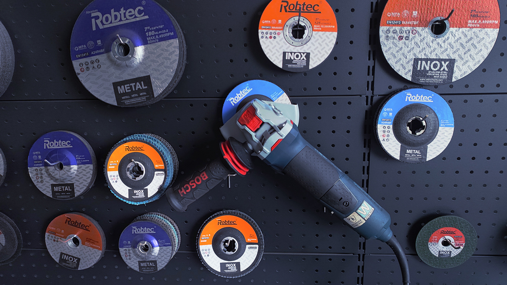 A Bosch Professional angle grinder is hanging on a wall with grinding discs.