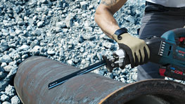 Рабочий использует сабельную пилу Bosch Professional на металлической трубе.