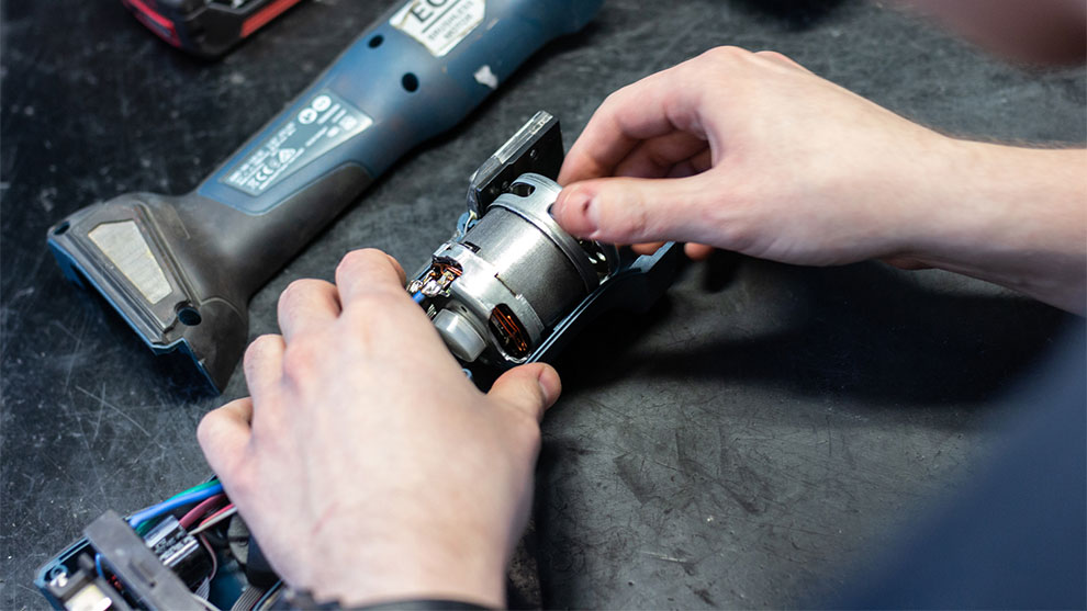 En person reparerer en Bosch Professional batteriværktøjsmotor.