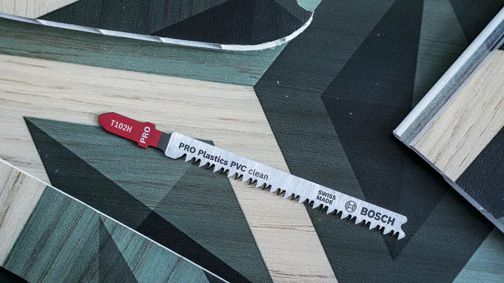 Jigsaw blade for cutting plastic and wood materials on a patterned surface.
