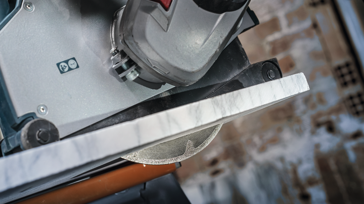 Tile saw cutting through a marble slab.