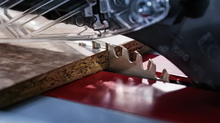 Sierra circular cortando un trozo de tablero de partículas.