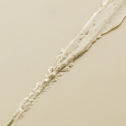 Bead of white sealant applied along a surface seam.