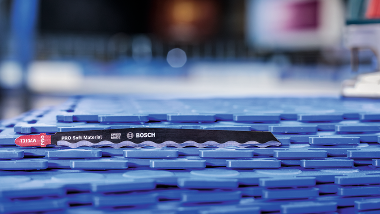 Saw blade for cutting soft materials placed on a blue plastic surface.