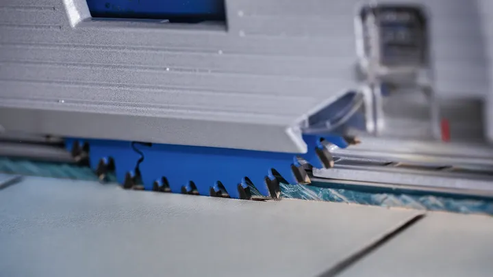 Circular saw blade cutting through a sheet of tile.
