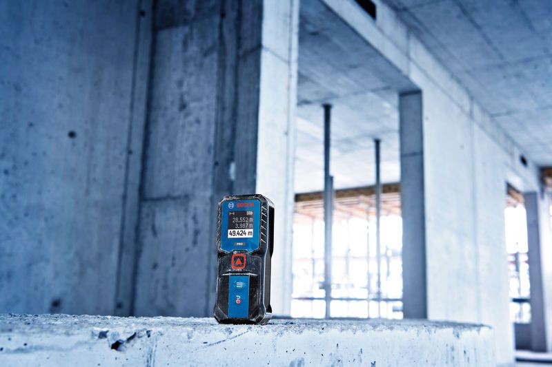 Laser measure placed on a concrete surface at a building construction site.