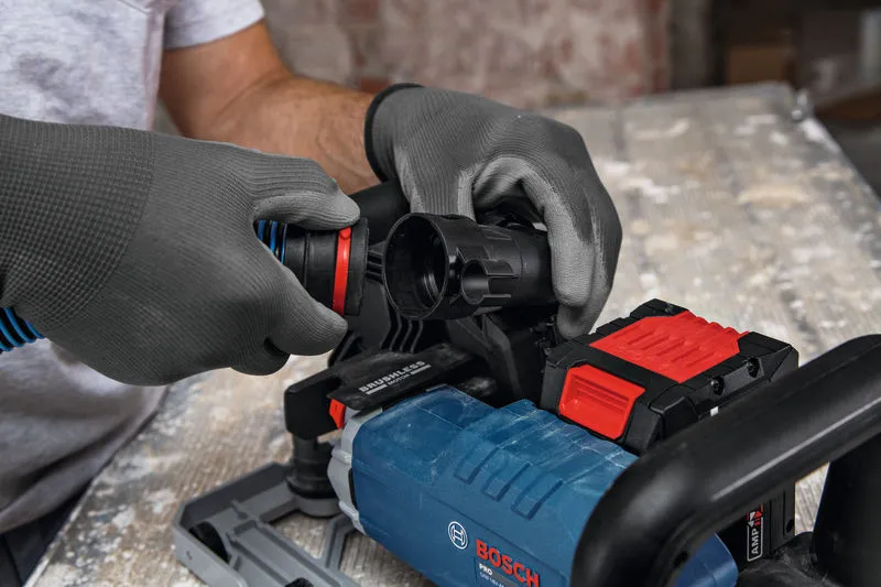 Person wearing safety equipment connects a vacuum hose to a wall chaser.