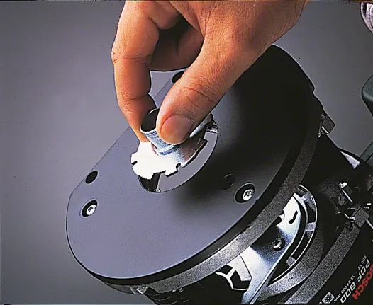 Hand inserting a collet nut into a router base for tool assembly.