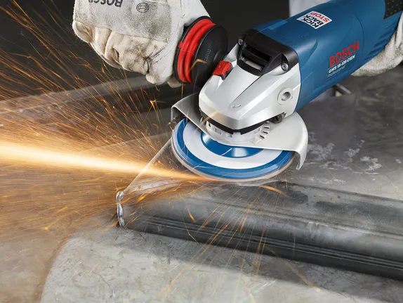 Trabalhador que utiliza equipamento de segurança tritura metal, produzindo faíscas brilhantes.