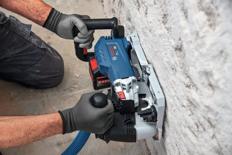 Uma pessoa que utilize equipamento de segurança utiliza uma fresadora de parede para abrir um sulco no reboco.