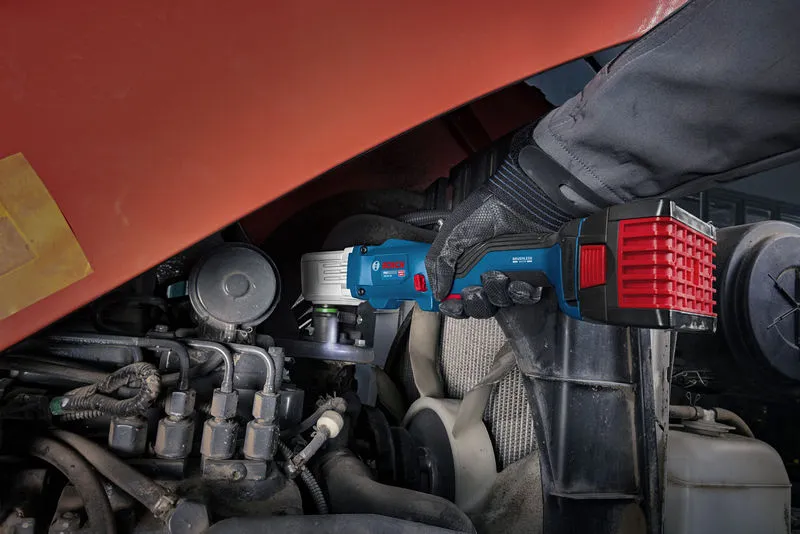 Uma pessoa que utilize equipamento de segurança utiliza uma chave de impacto sem fios num motor.