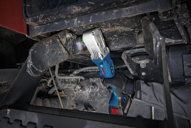 Uma pessoa que utilize equipamento de segurança utiliza uma chave de impacto sem fios em máquinas pesadas.