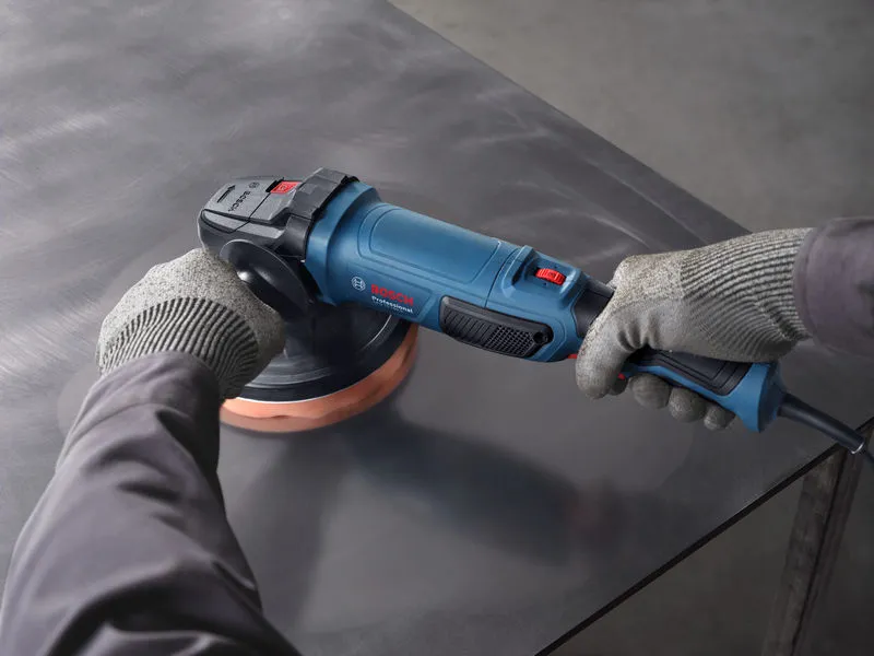A person wearing safety equipment uses a polisher on a metal surface.