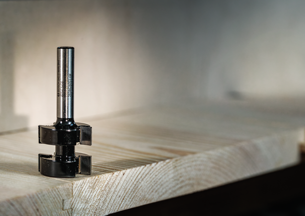 Router bit resting on a wooden board for precise edge cutting.