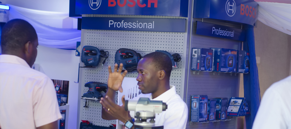 Two men discuss Bosch Professional tools in a bright display area.