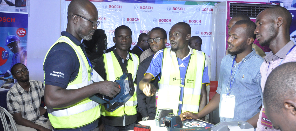 Bosch Professional tools showcased by a group of men wearing safety vests at an event.