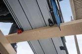 Met een invalzaag wordt een houten balk op een bouwplaats doorgezaagd.